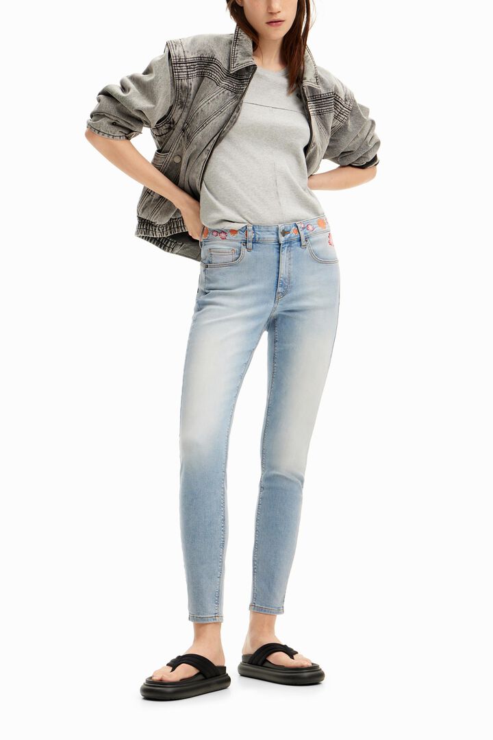 Long denim pants with flowers on the waist. | Desigual