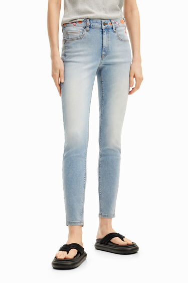 Calça jeans comprida com flores na cintura. | Desigual