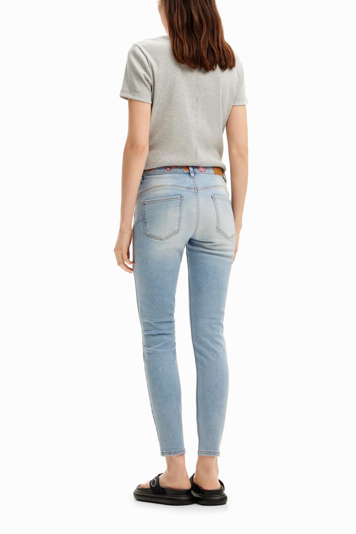 Long denim pants with flowers on the waist. | Desigual